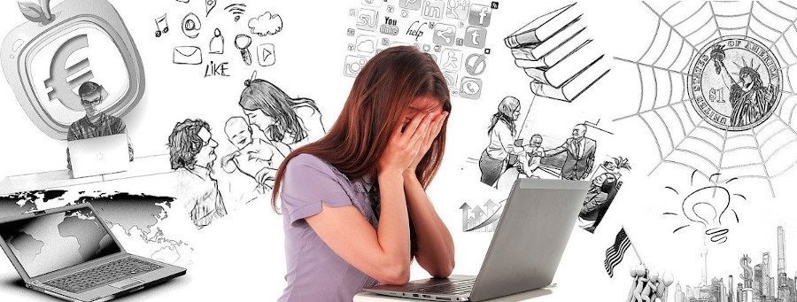 woman looking upset holding her hands over her face and leaning towards a laptop