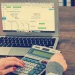 woman using calculator to help with bookkeeping and taxes